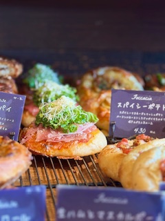 丘の上のパン屋さんの陳列されたパン生ハムと野菜が乗ったパン