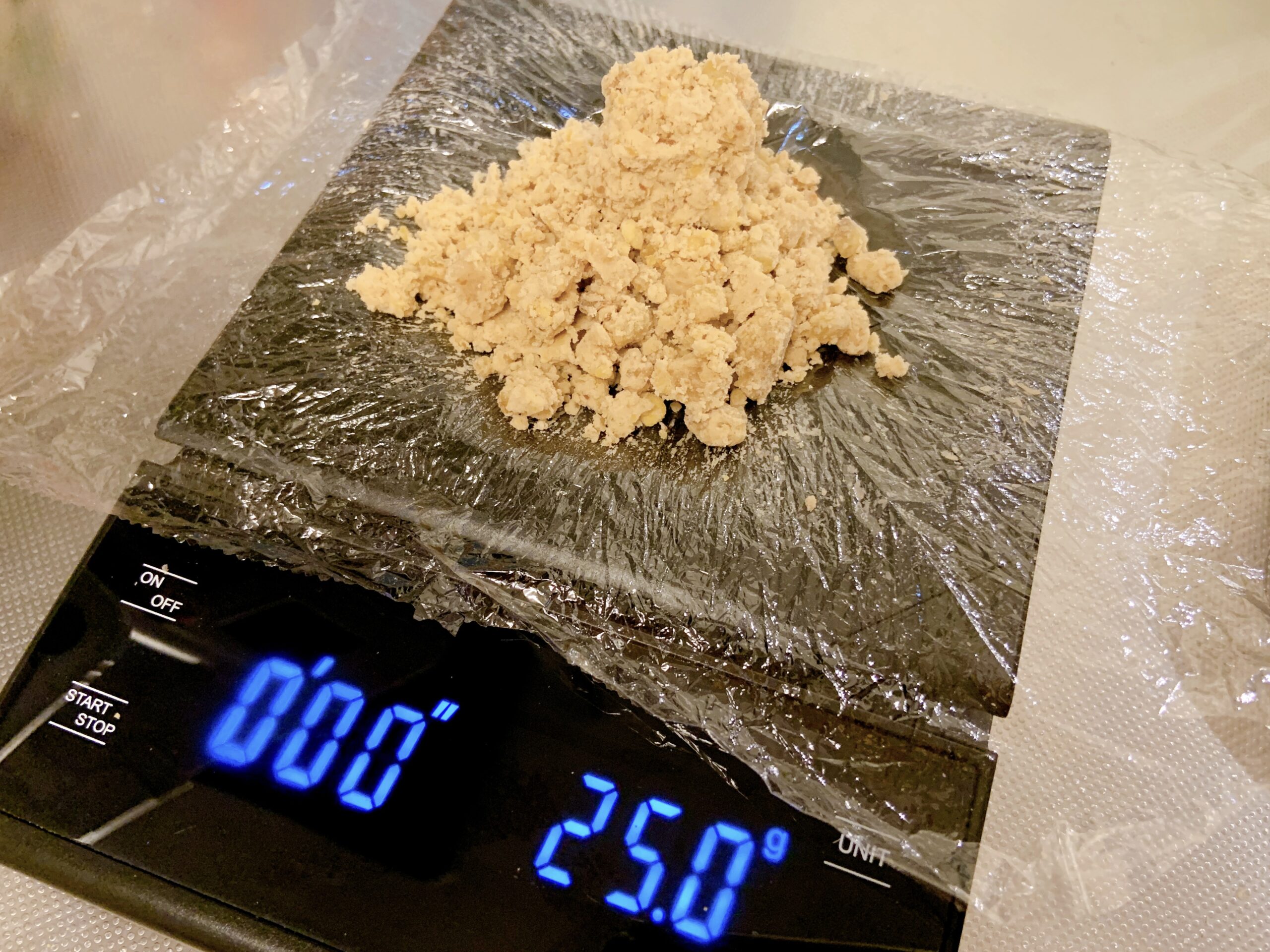 栗きんとんを作るために蒸した栗に砂糖を混ぜて25グラムずつに分けるところ