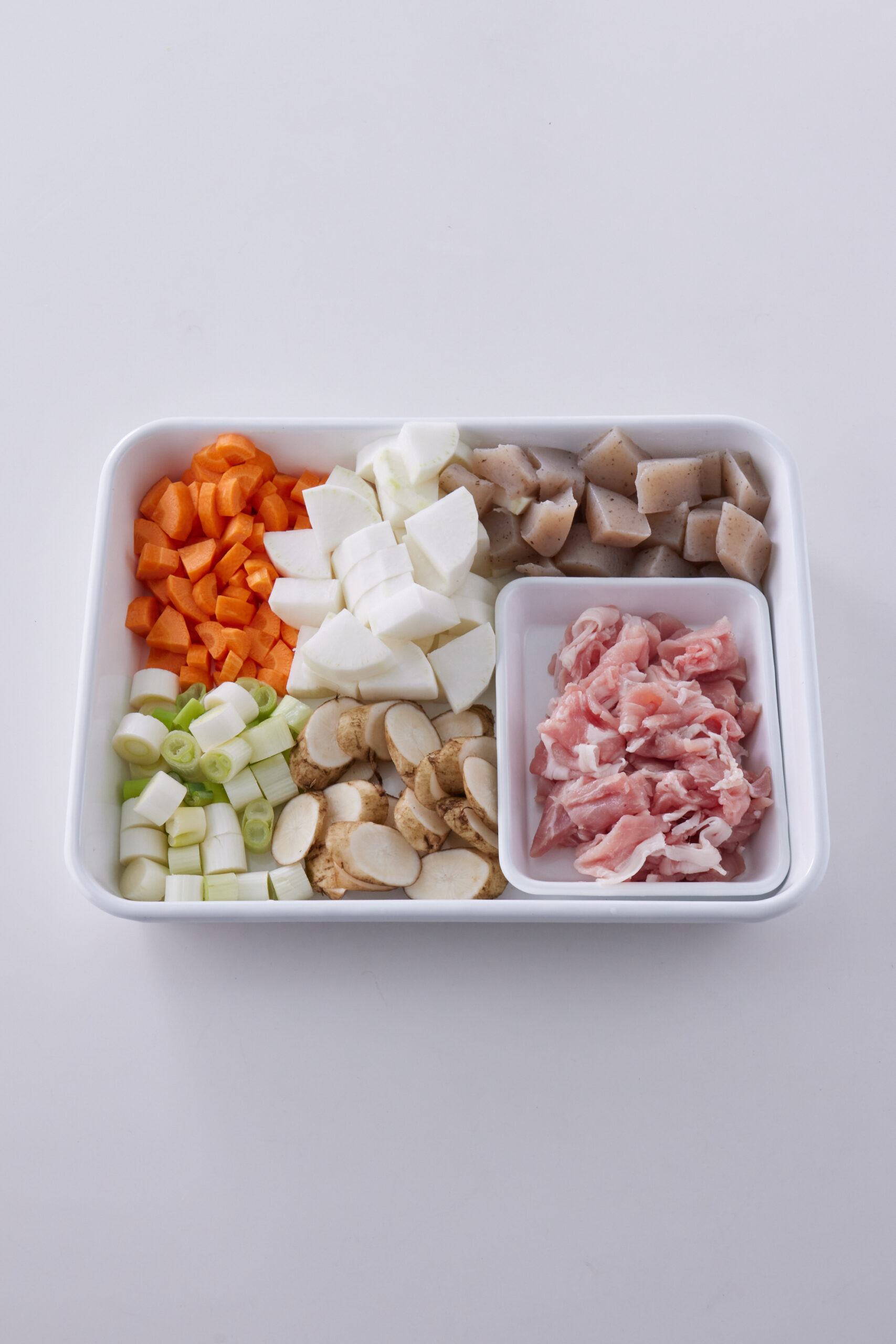 こんにゃく、ごぼう、にんじん、大根、ねぎ、豚肉を切る。