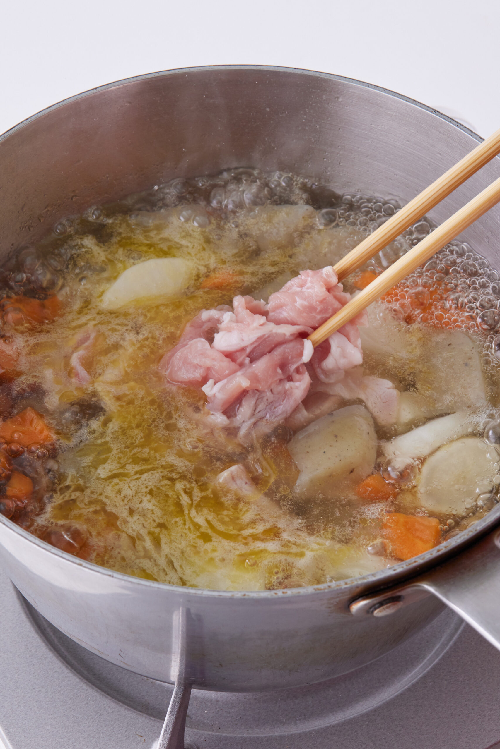 だし汁を加え、煮立ったら豚肉を加える