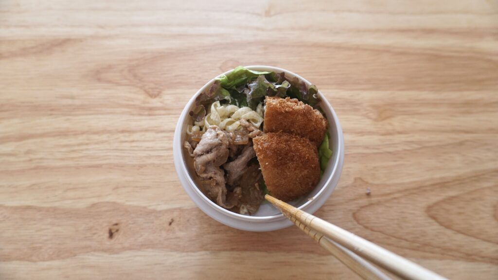 ダイソーのスープジャーに炊き立てご飯を入れたお弁当。おかずはコロッケ、卵焼き、レンコンのひじき煮、マカロニ、豚生姜焼きです。