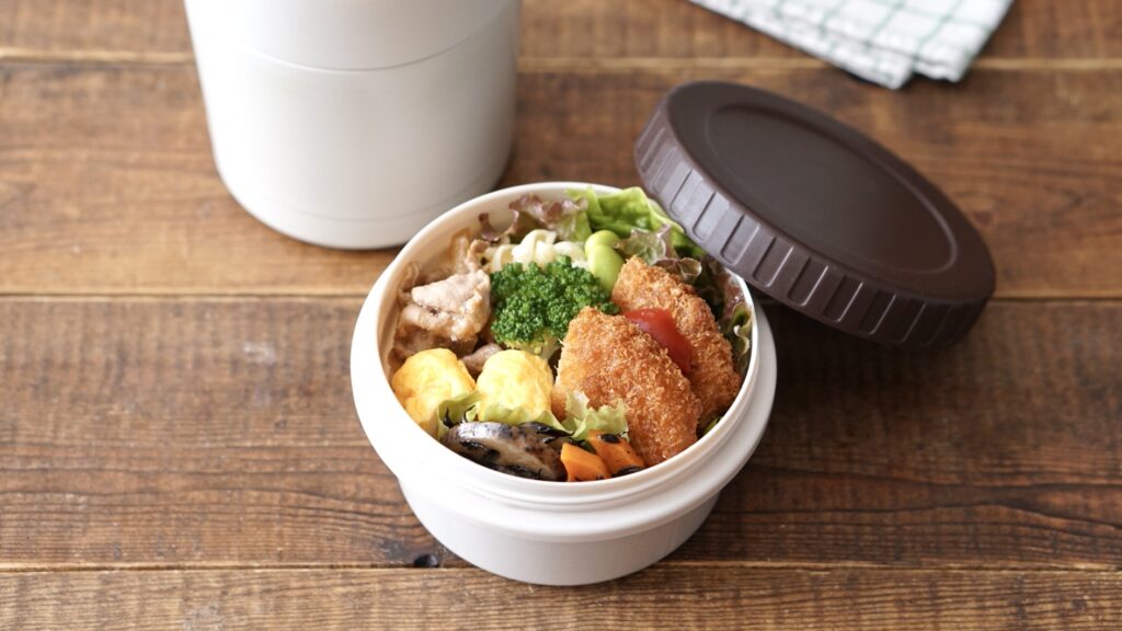 ダイソーのスープジャーに炊き立てご飯を入れたお弁当。おかずはコロッケ、卵焼き、レンコンのひじき煮、マカロニ、豚生姜焼きです。