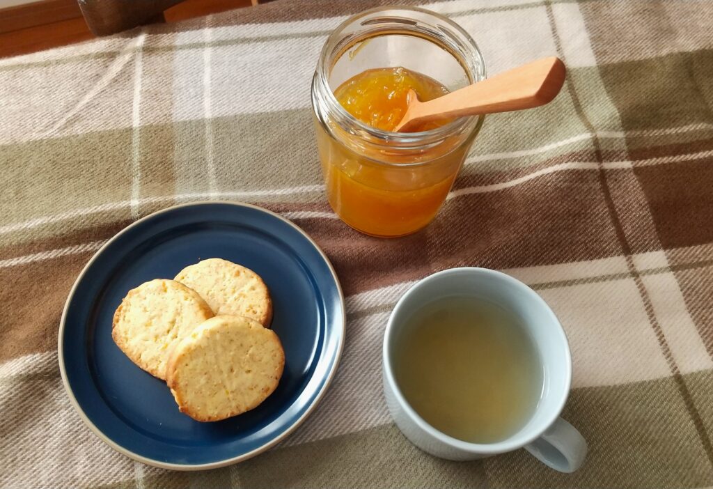 テーブルの上の柚子ジャムとクッキーとお茶