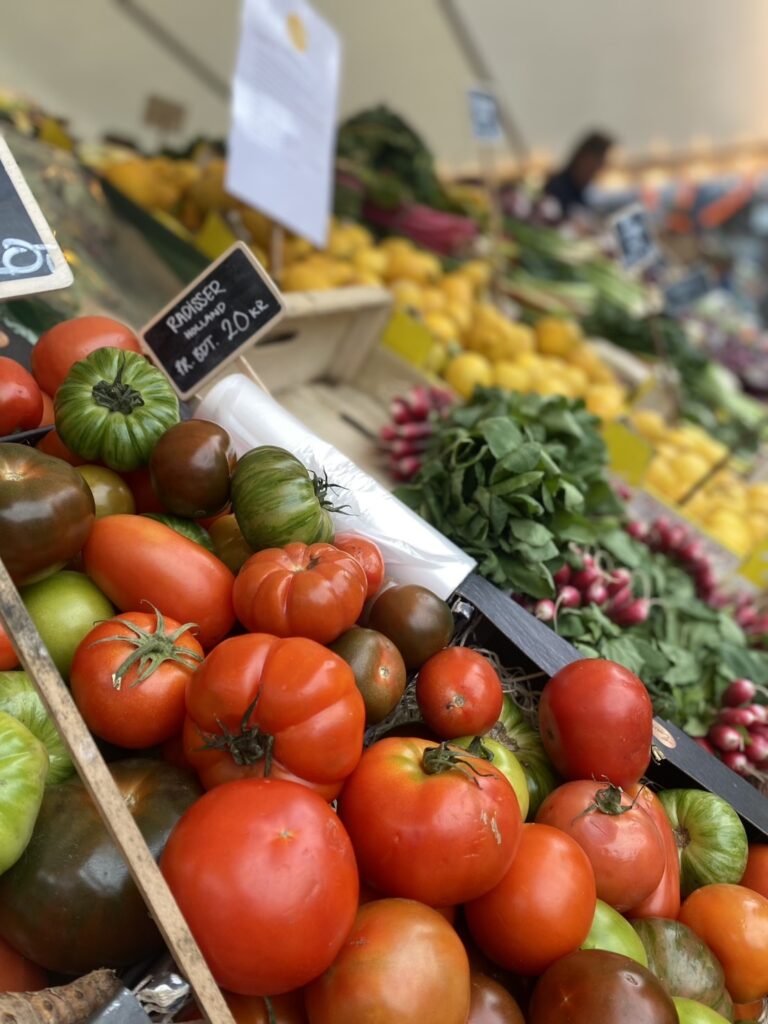 デンマークの市場のカラフルなトマトと春野菜