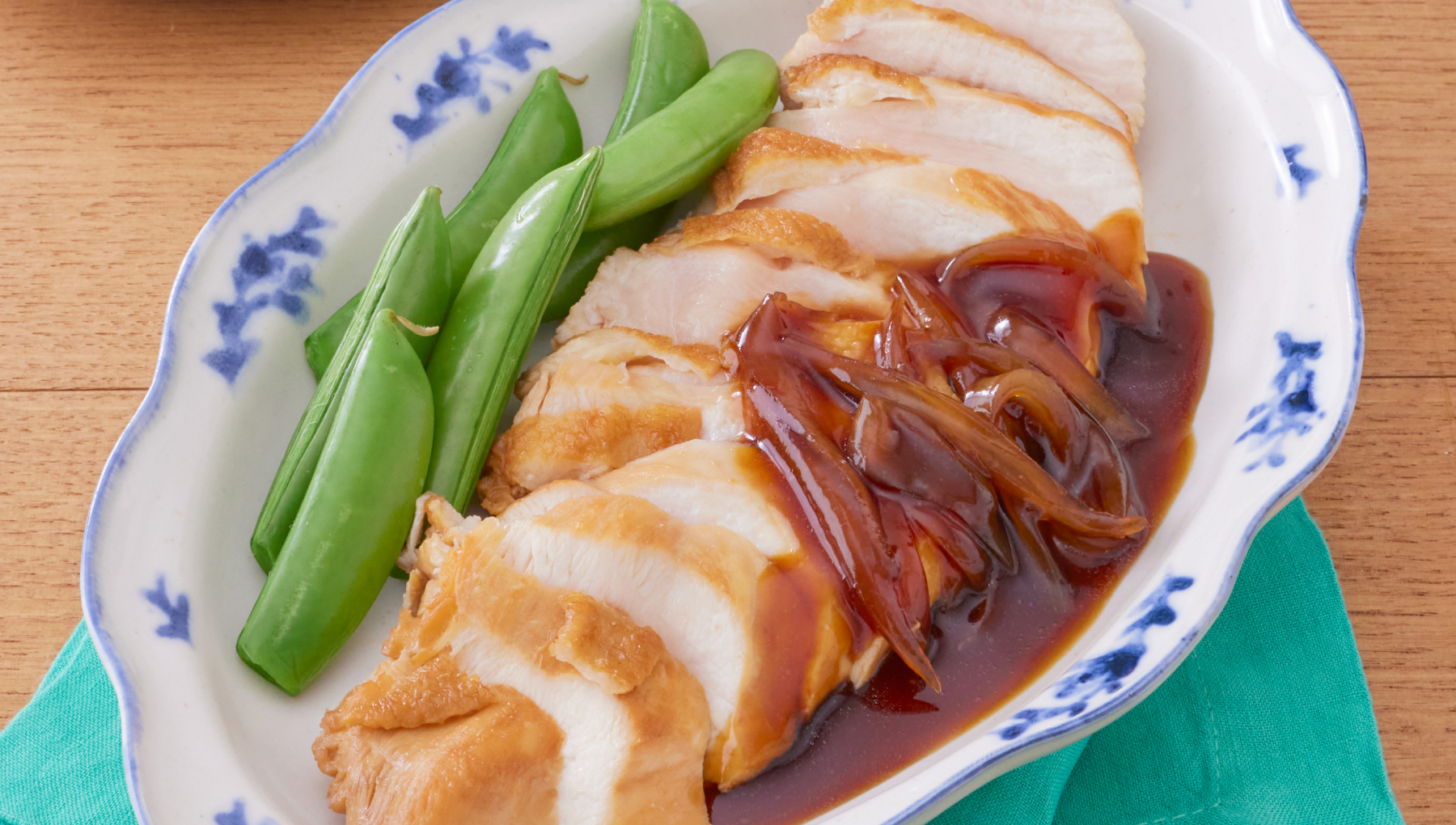鴨ロース風鶏胸肉の柔らか煮。煮つけた鶏胸肉に副菜のえんどう豆が添えられている