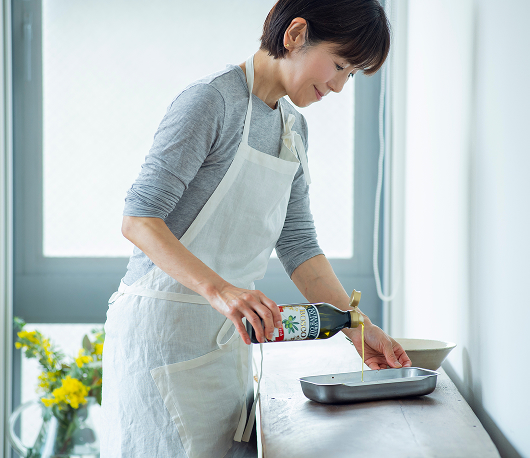 オリーブオイルで調理をしているワタナベマキさんの写真