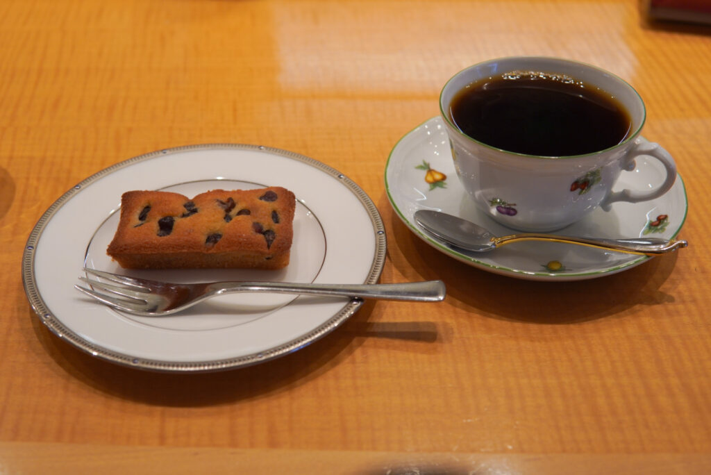 caffè Verdiのデカフェのホットコーヒーと、大納言のフィナンシェが、それぞれお皿に乗っています。