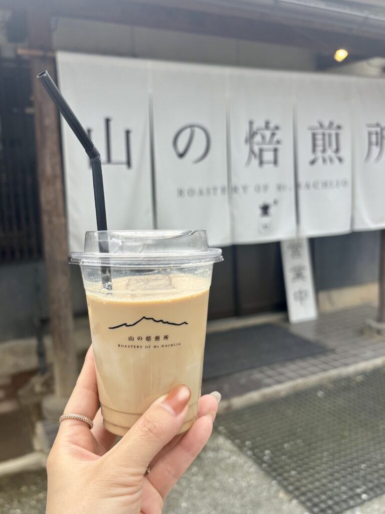 山の焙煎所の外観と手に持ったアイスラテ