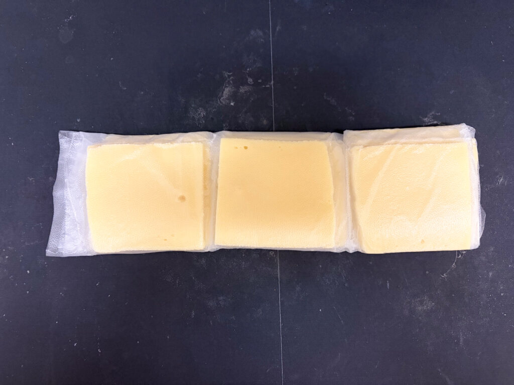 コストコのラクレットチーズをプレスンシールの上に並べて、たたんでいる