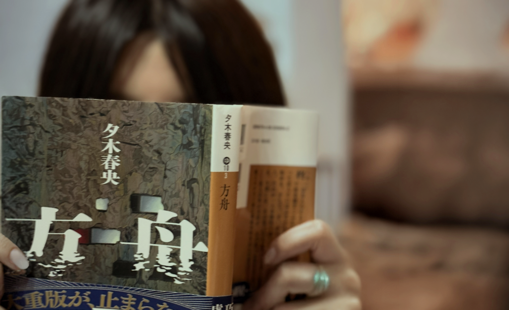 「方舟」夕木春央著 講談社文庫 を読む女性