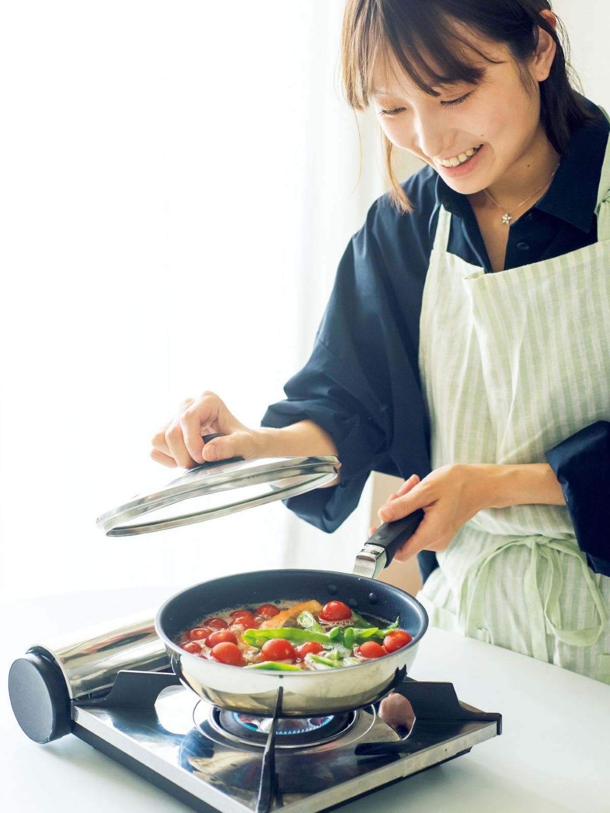焼いた鮭に野菜を加えふたをして蒸している様子